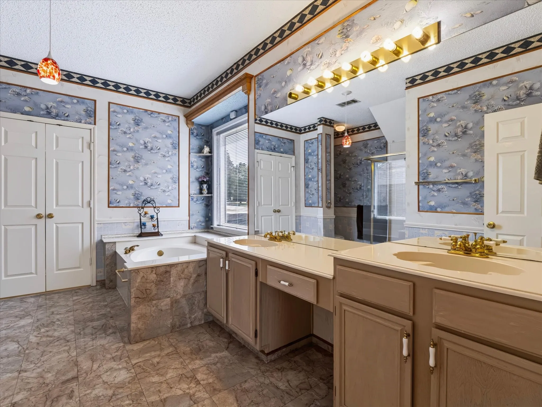 Dual vanity with integrated sinks, built-in soaking tub, and tiled flooring