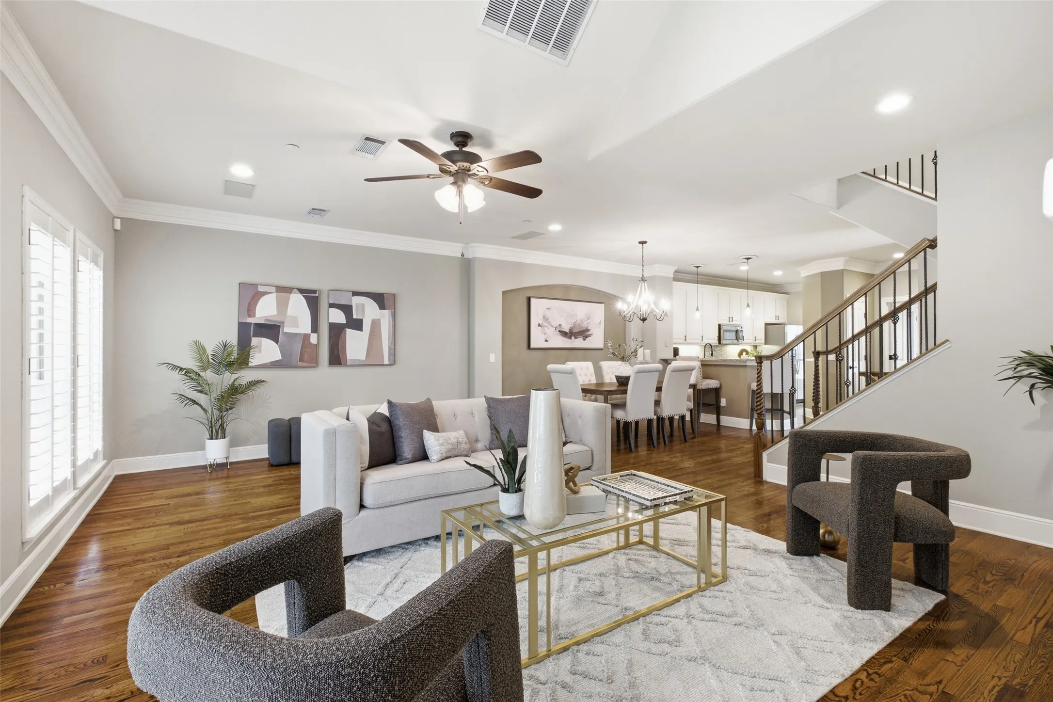Hardwood flooring throughout, plantation shutters, crown molding, ceiling fan, and recessed lighting