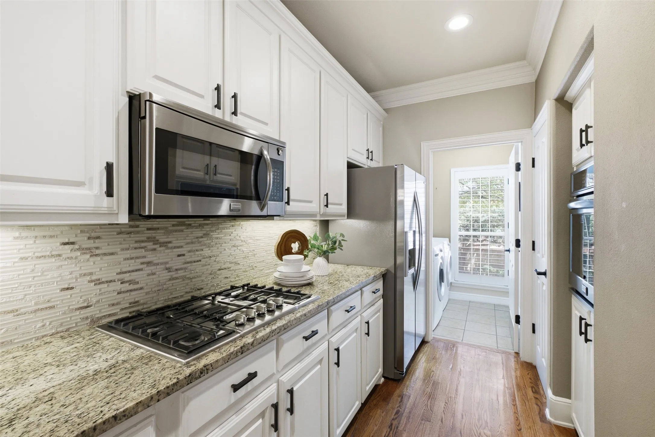 Kitchen featuring white cabinetry, stainless steel appliances, a gas cooktop, and granite countertops