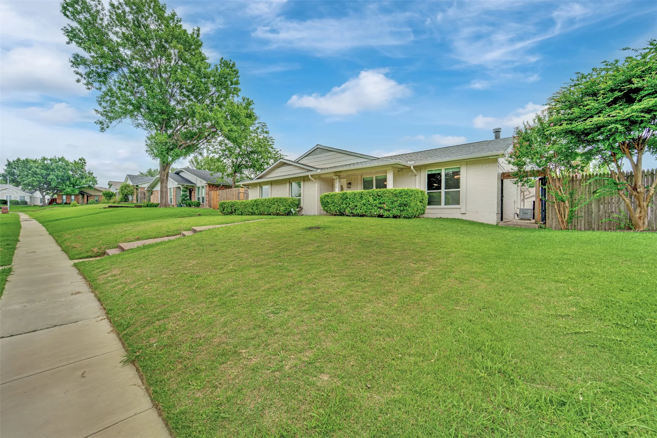 Single-story residence featuring a neutral exterior, white trim, and a shingled roof