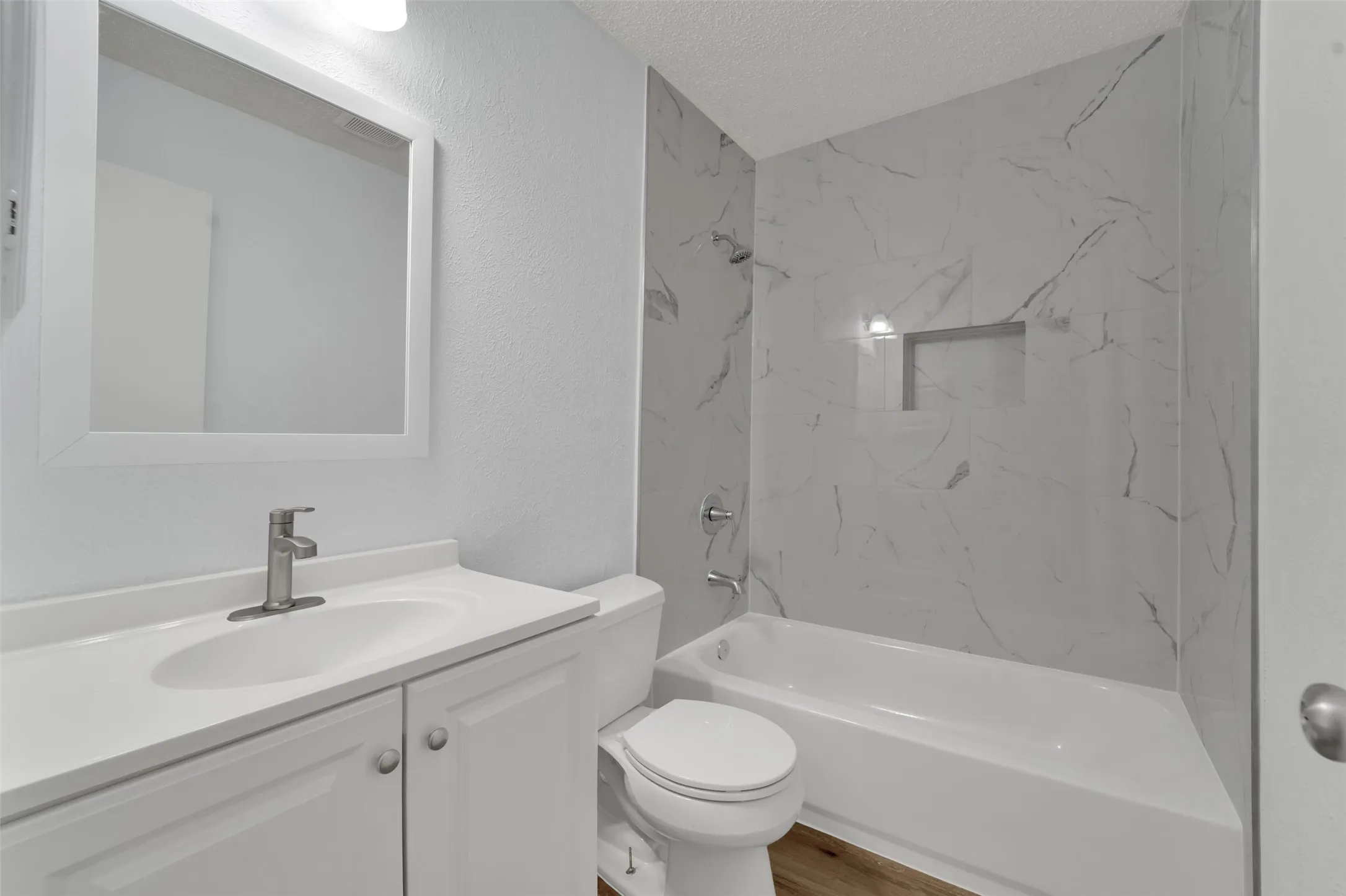 Contemporary bathroom featuring a floating vanity with rectangular undermount sink, quartz countertop, and chrome faucet