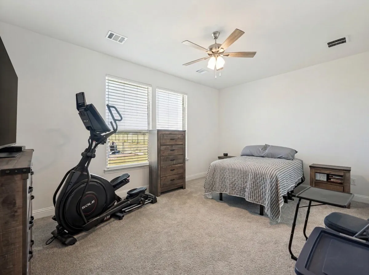 Primary Bedroom Carpeted room with two windows featuring blinds, a ceiling fan with integrated lighting, and white walls