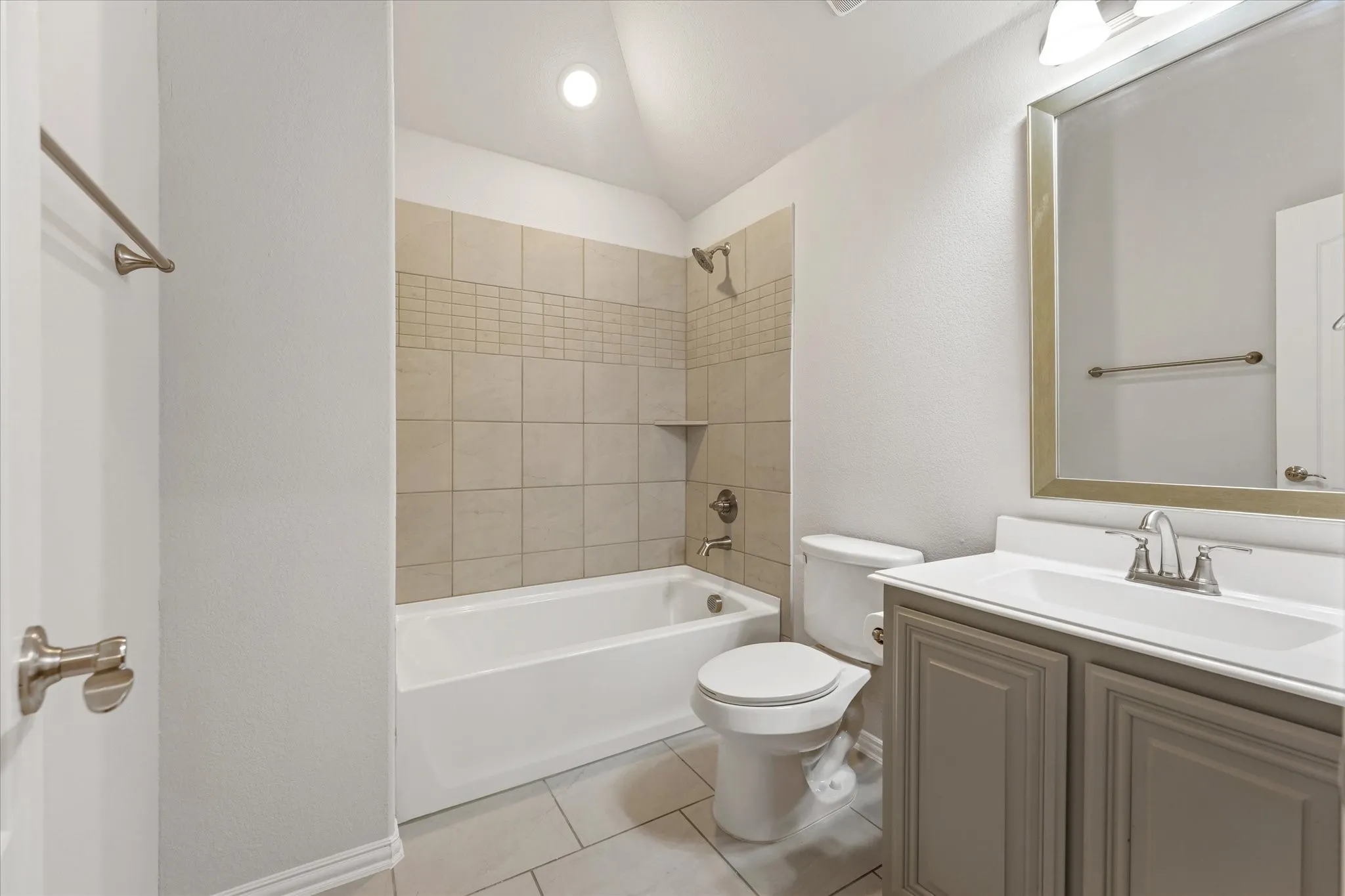 Conveniently located off the upstairs game room, this full bath features a tiled tub/shower surround, spacious vanity, framed mirror, and neutral finishes.