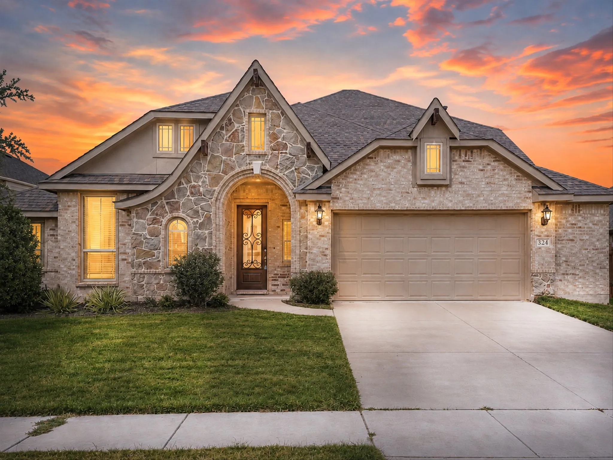 Welcome Home! Beautiful stone and brick exterior with charming architectural details, a welcoming entryway, and spacious driveway.