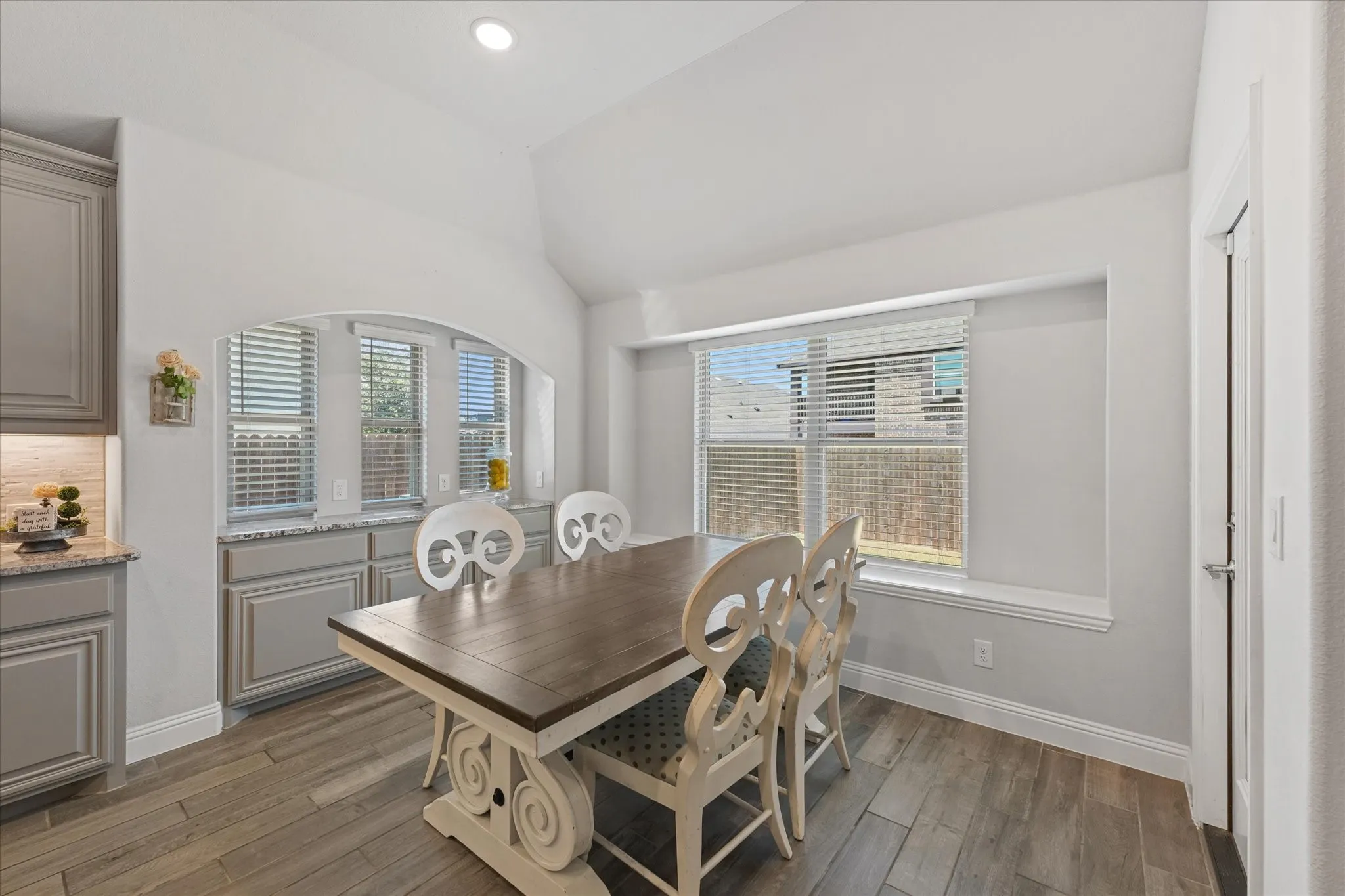 Large eat-in kitchen with abundant natural light, generous cabinetry, a charming built-in window bench, and blinds.