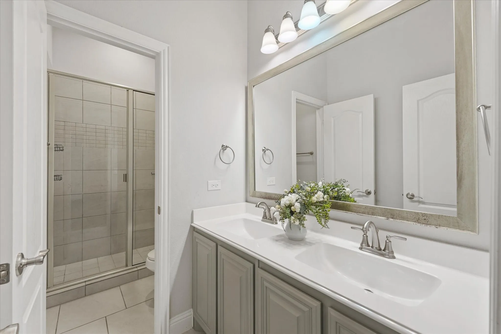 Dual vanity with undermount sinks, gray shaker cabinetry, and brushed nickel fixtures