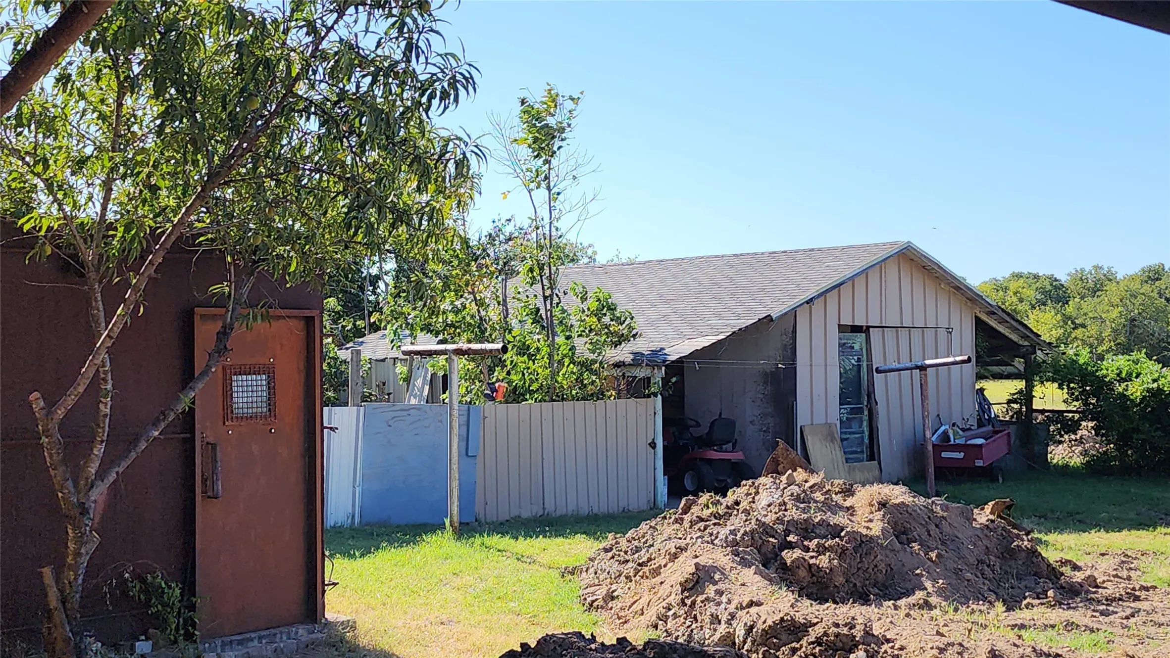 small building on the right is a storm shelter, the back building is a shop or storage building.