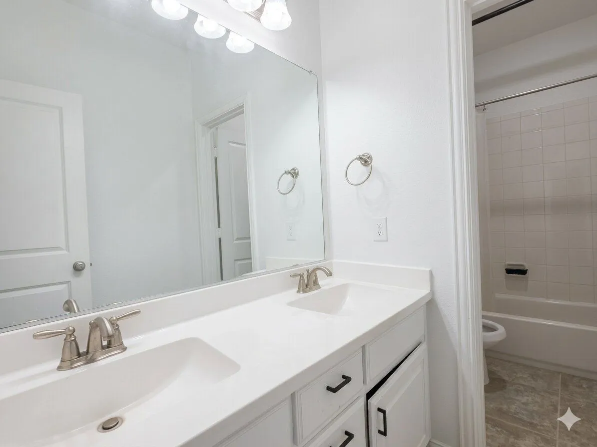 Double vanity with white countertop, chrome faucets, and integrated sinks