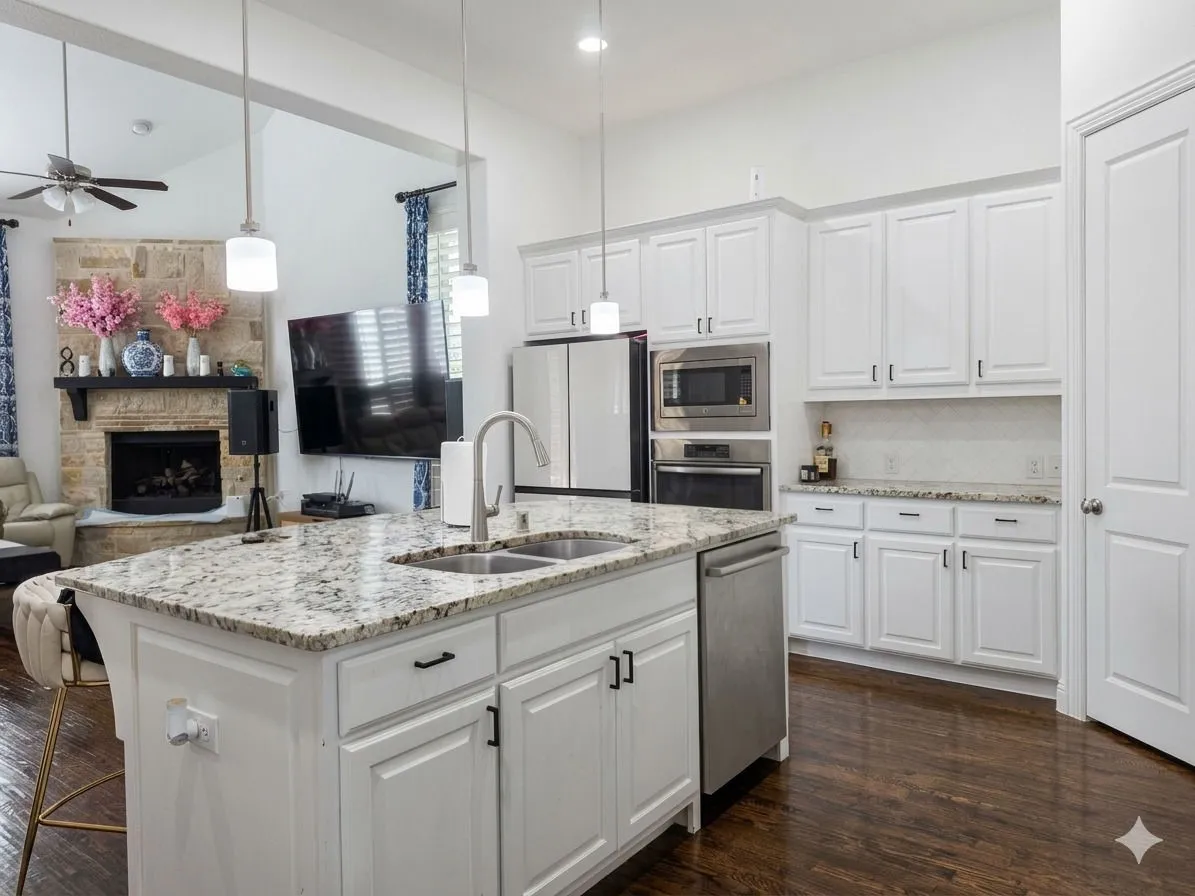 Kitchen island with integrated double basin sink, stainless steel dishwasher, and pendant lighting
