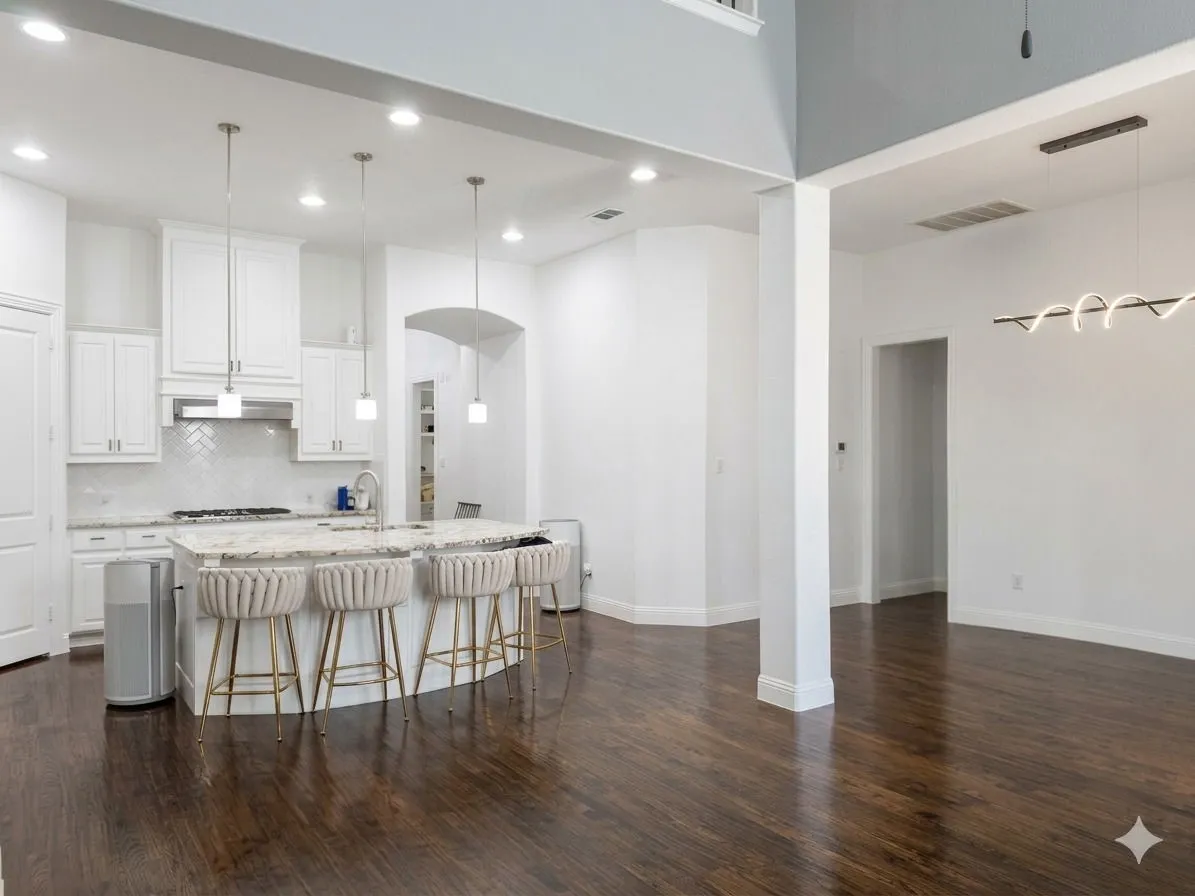 Gourmet kitchen with white cabinetry, a herringbone tile backsplash, an expansive island with a stone countertop, and pendant lighting