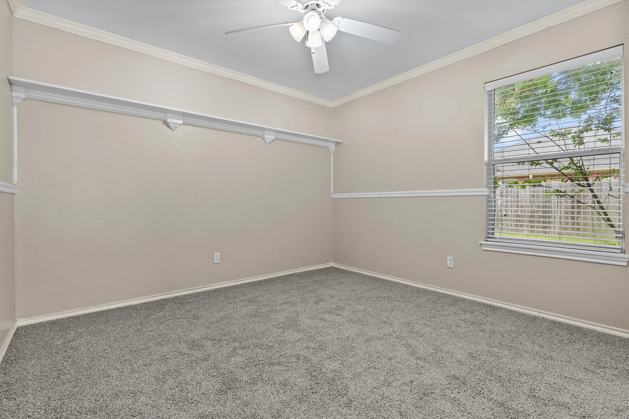 Bright secondary bedroom featuring neutral wall finishes, plush carpeting, ceiling fan with integrated lighting, and dual windows allowing natural light throughout the space