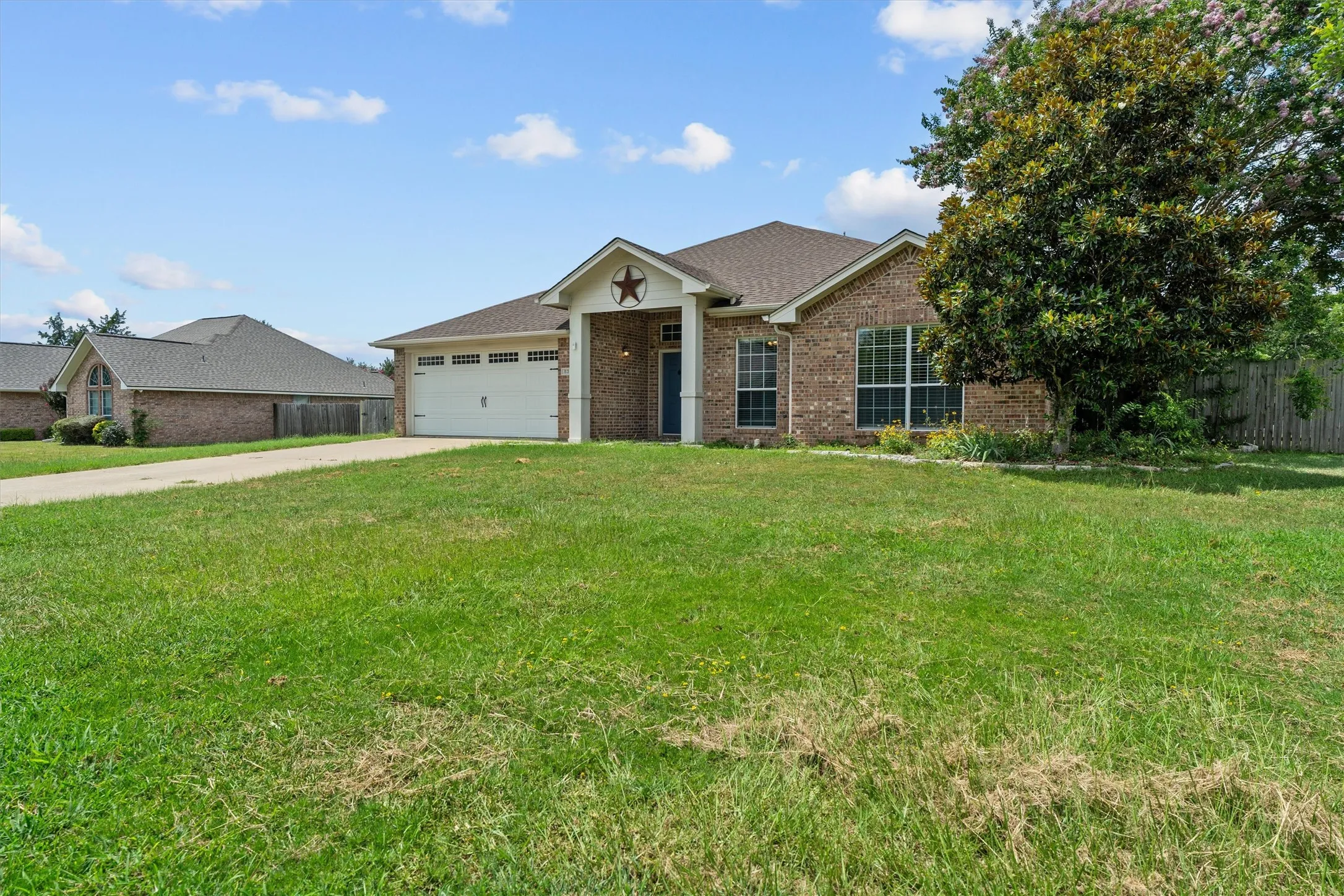 Brick exterior home situated on expansive manicured grounds featuring mature landscaping