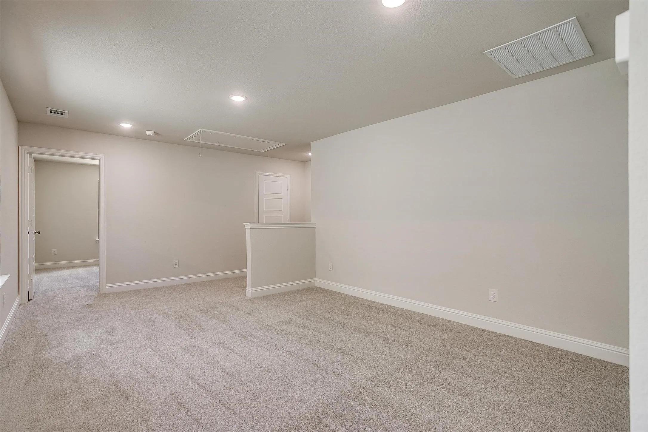 Carpeted floor, recessed lighting, neutral wall paint, white trim, interior doors