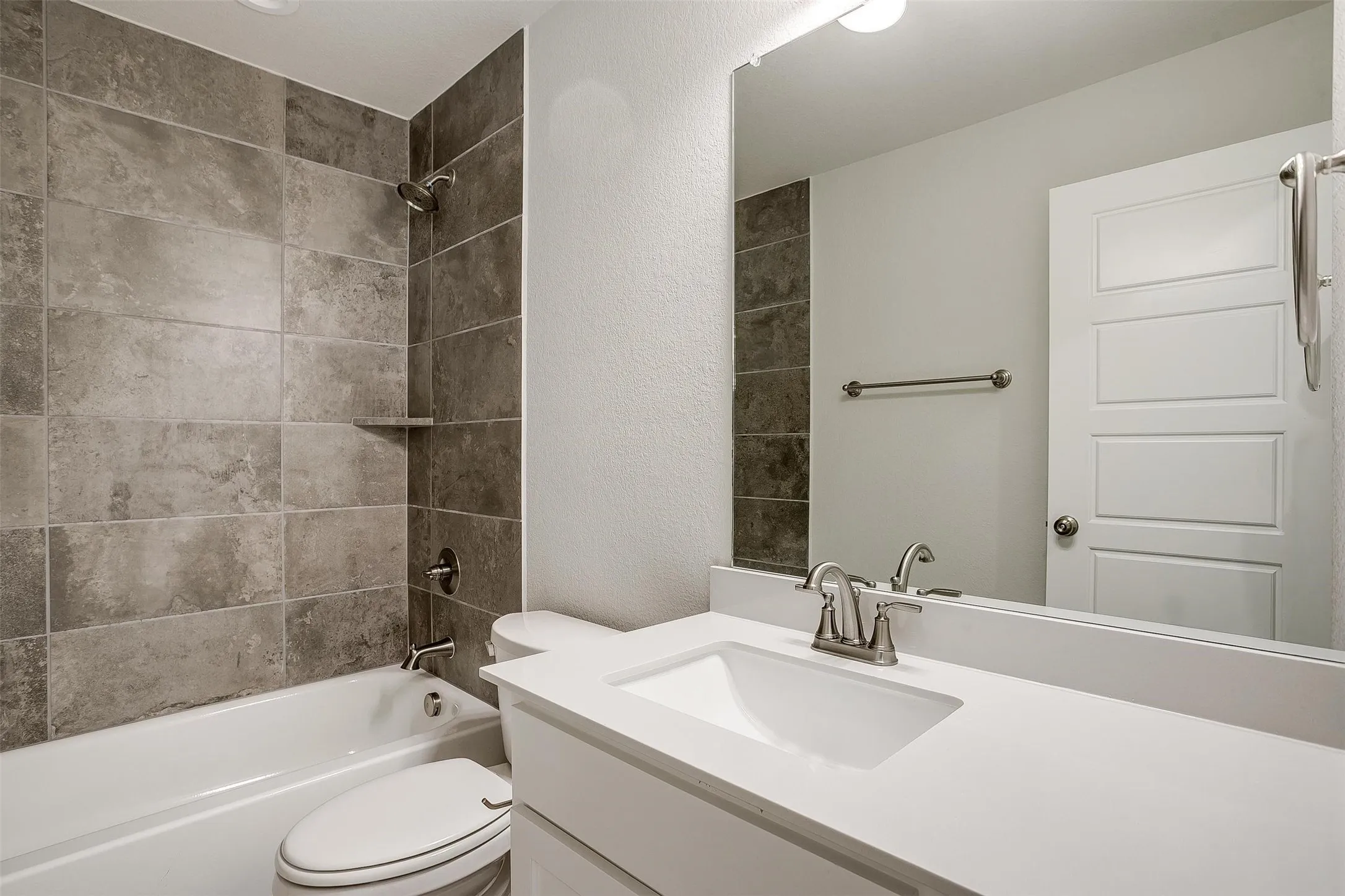 White vanity with an integrated rectangular sink and chrome faucet, set against a full-width mirror