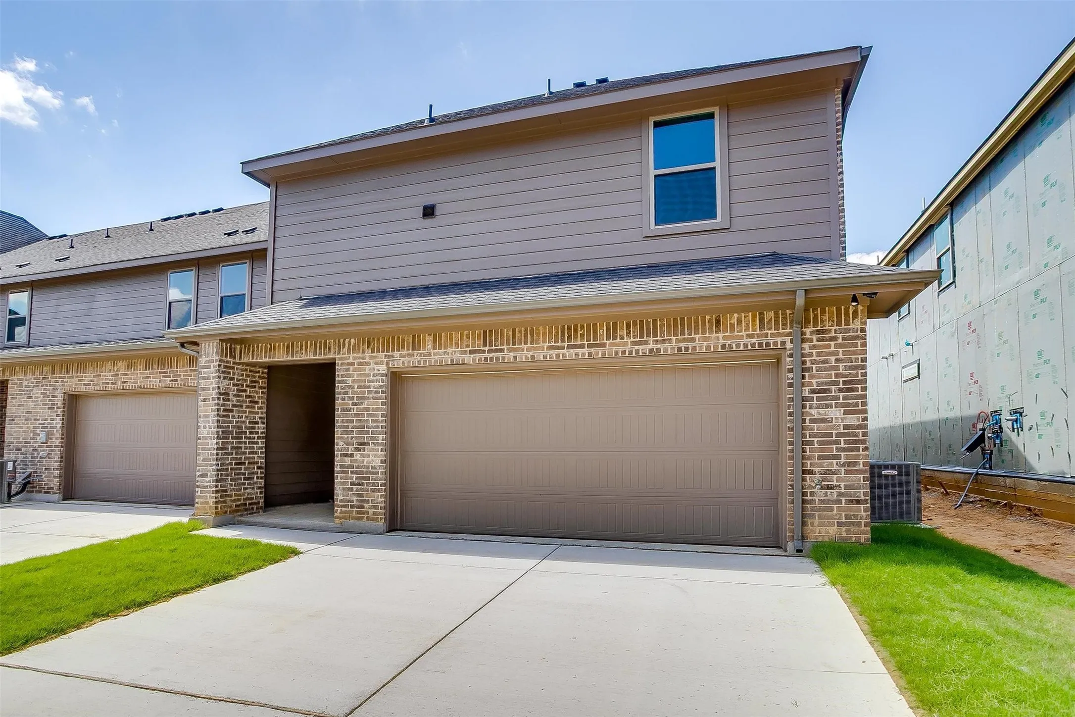 Brick and siding exterior with concrete driveways and attached garages