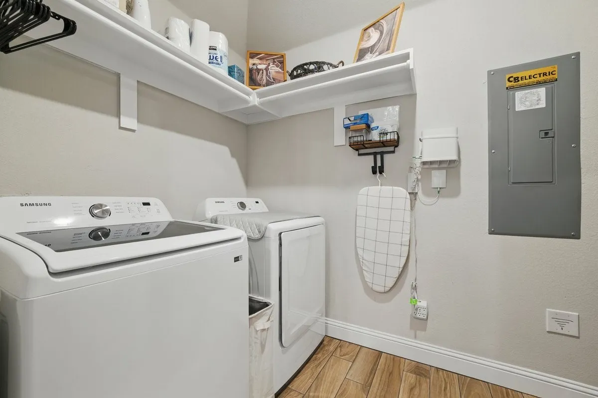 White wall shelving over laundry area with wood-finish flooring