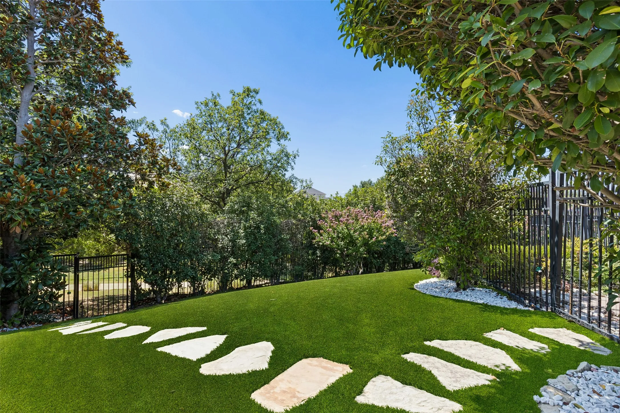 Backyard covered with turf for yearround green and access to trail to community garden