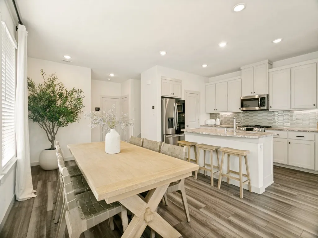 Kitchen featuring a center island with bar seating, stainless steel appliances, light-toned cabinetry