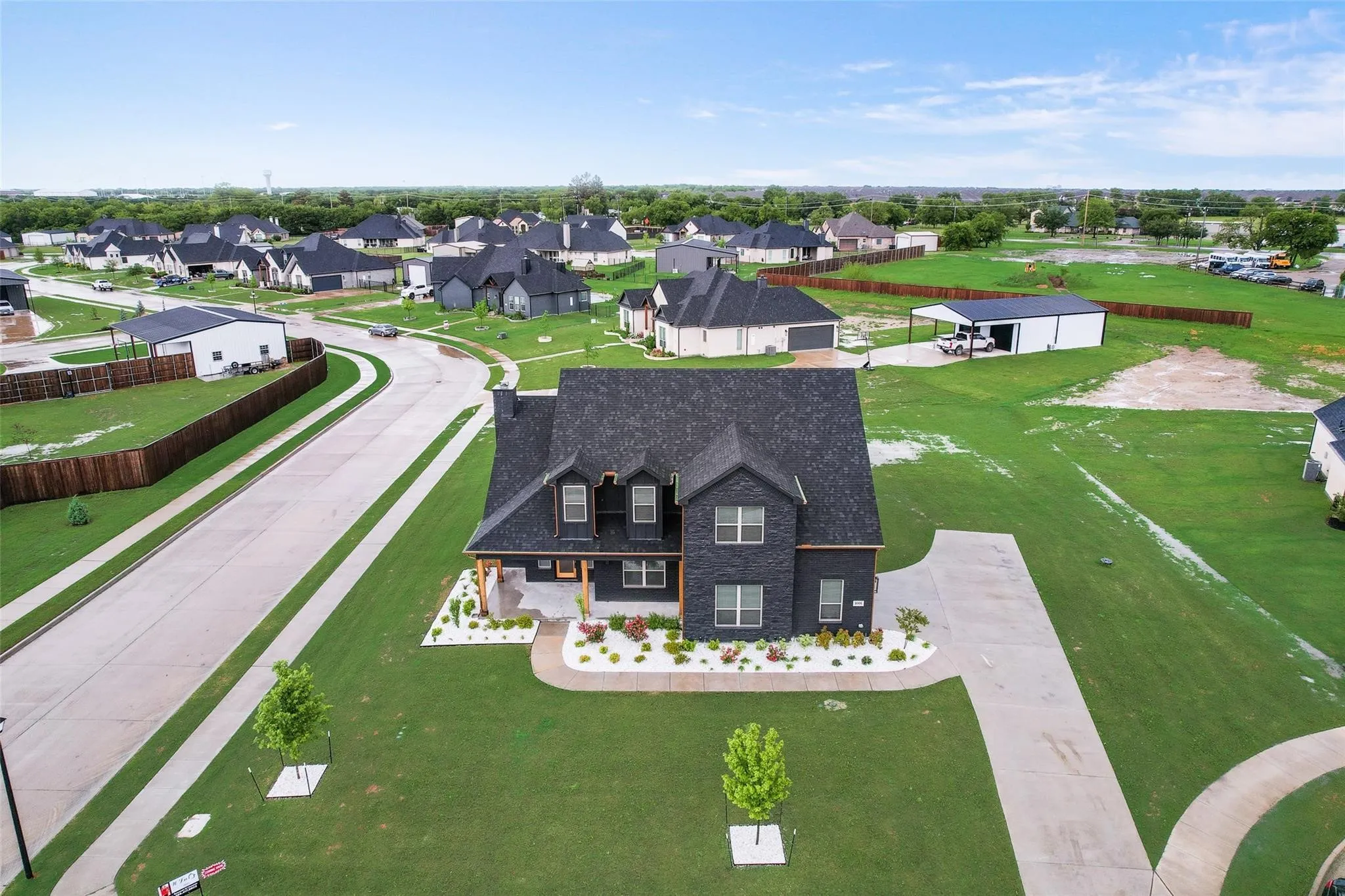 Contemporary two-story residence featuring a dark brick exterior and a dark shingle roof