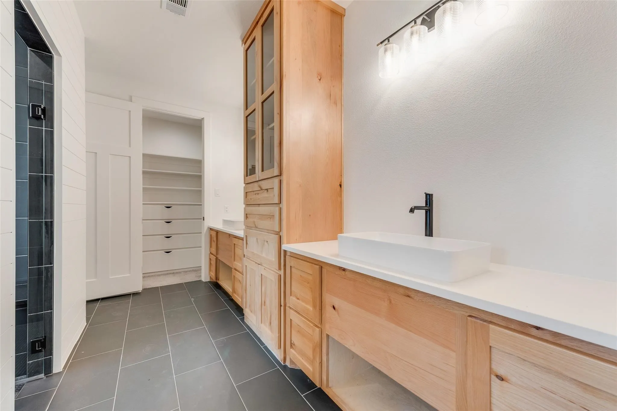 Modern bathroom featuring a rectangular vessel sink, matte black faucet, and a contemporary vanity light fixture