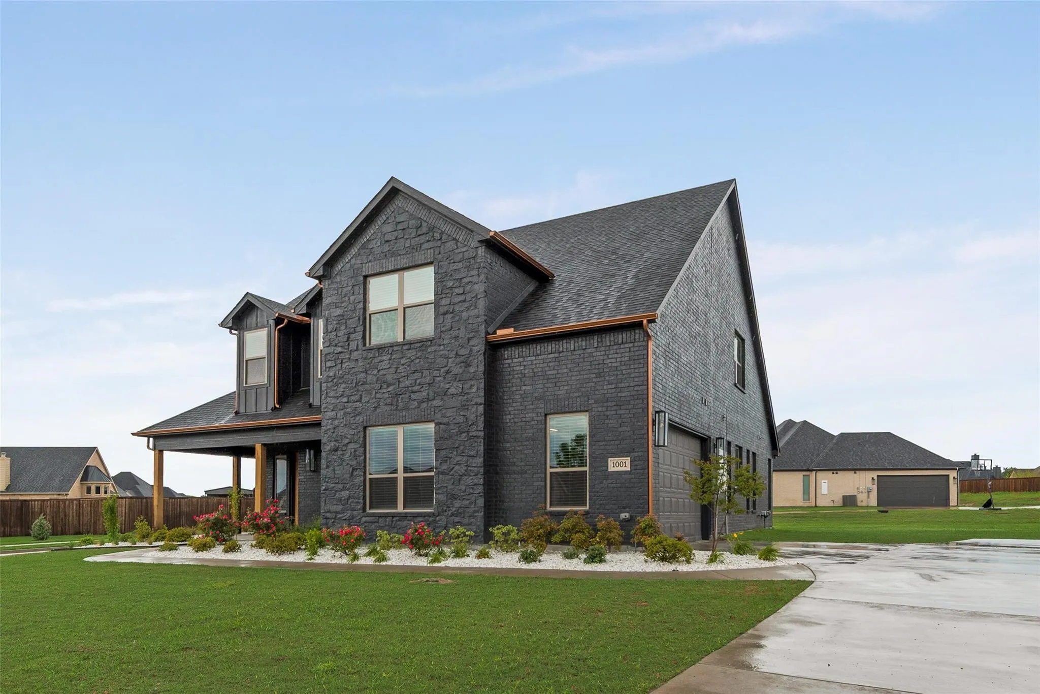 Modern two-story residence featuring a dark brick and board-and-batten exterior