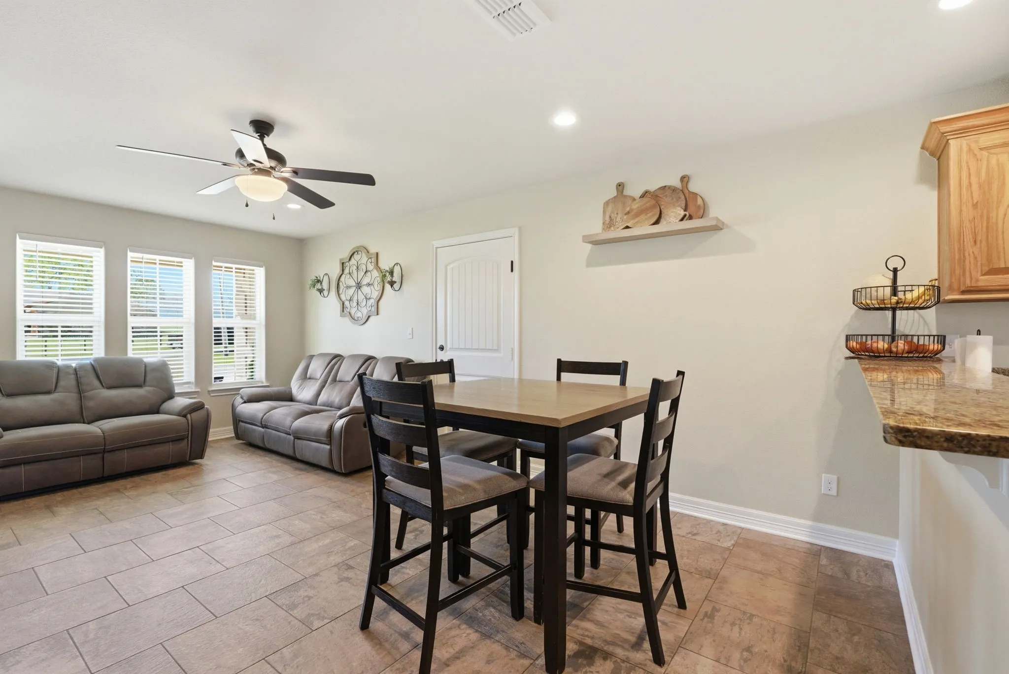 Open-concept living space with tile flooring, a ceiling fan, and recessed lighting