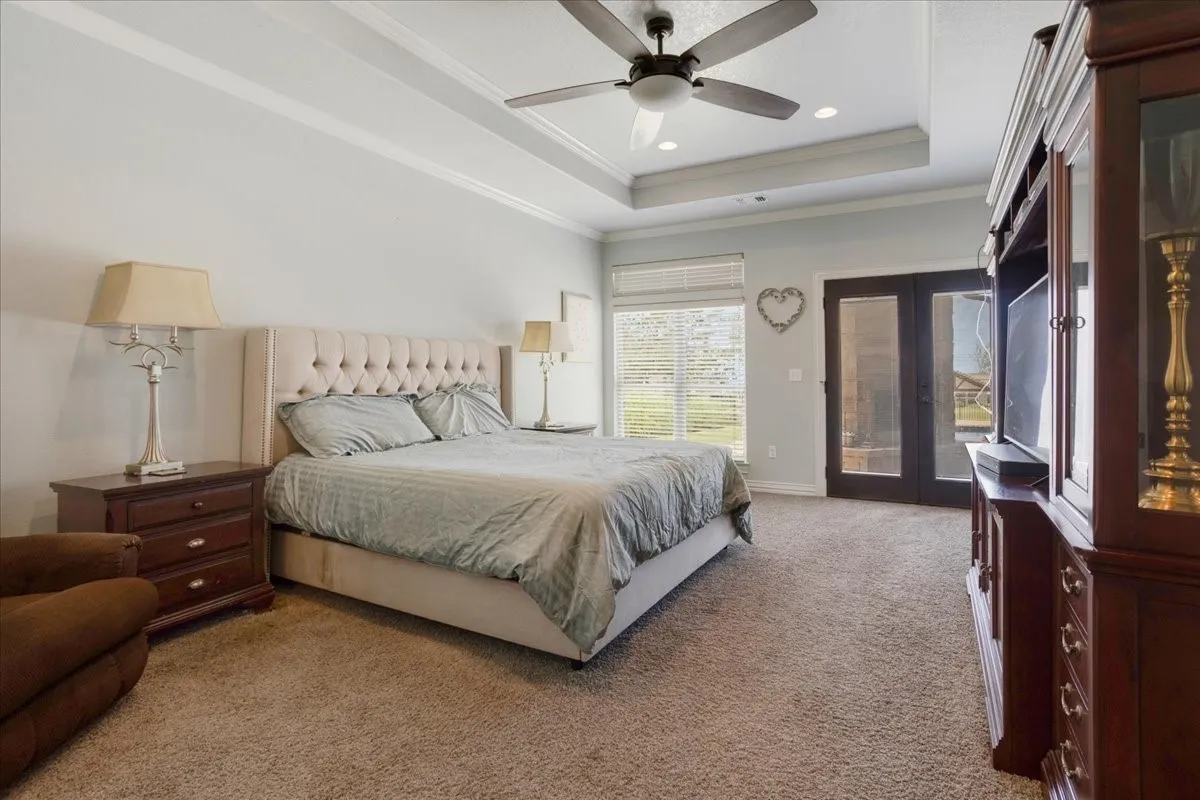 Tray ceiling with crown molding, ceiling fan, and recessed lighting
