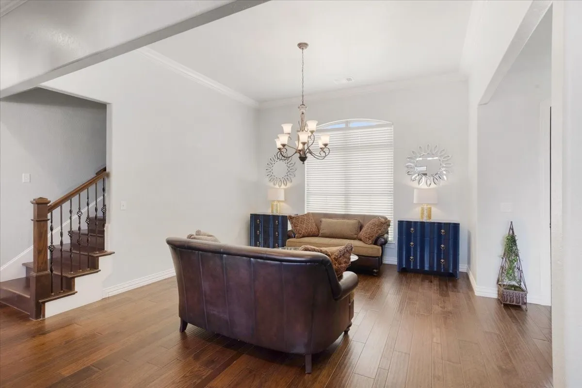 Wood-finish flooring throughout, with a classic staircase featuring wood treads and wrought iron balusters