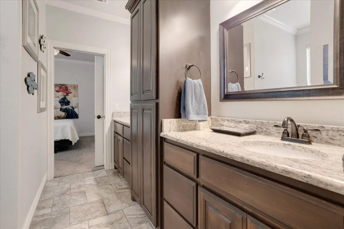 Vanity with an undermount sink, granite-style countertop, and dark wood-finish cabinetry