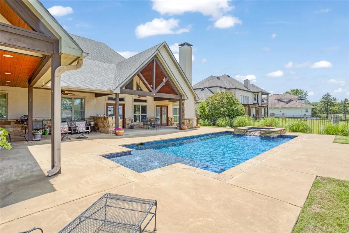 Expansive concrete patio with an integrated swimming pool and spa