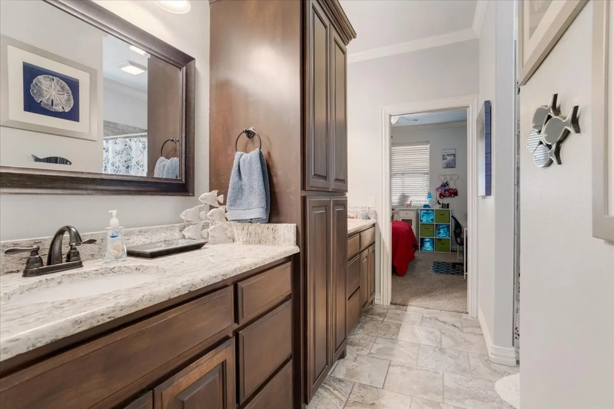 Dual vanity with integrated sinks, granite-style countertop, and dark wood-finish cabinetry