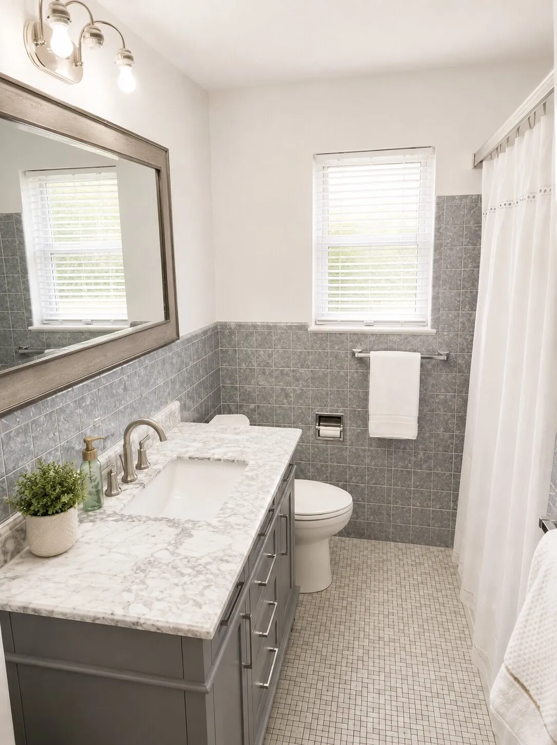 Bathroom featuring a vanity with a white stone countertop, undermount sink, and brushed nickel faucet