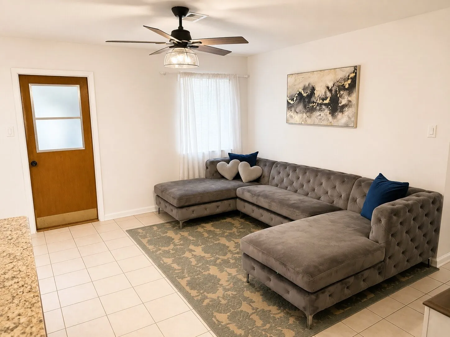 Recessed lighting, wood-finish door with frosted glass panels, ceiling fan with integrated lighting, white tile flooring, and solid surface countertop