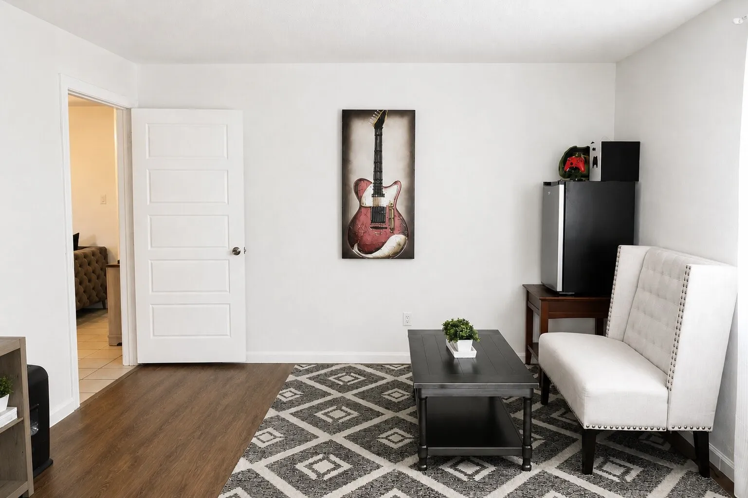Wood-finish flooring, white paneled interior door, and light-colored walls