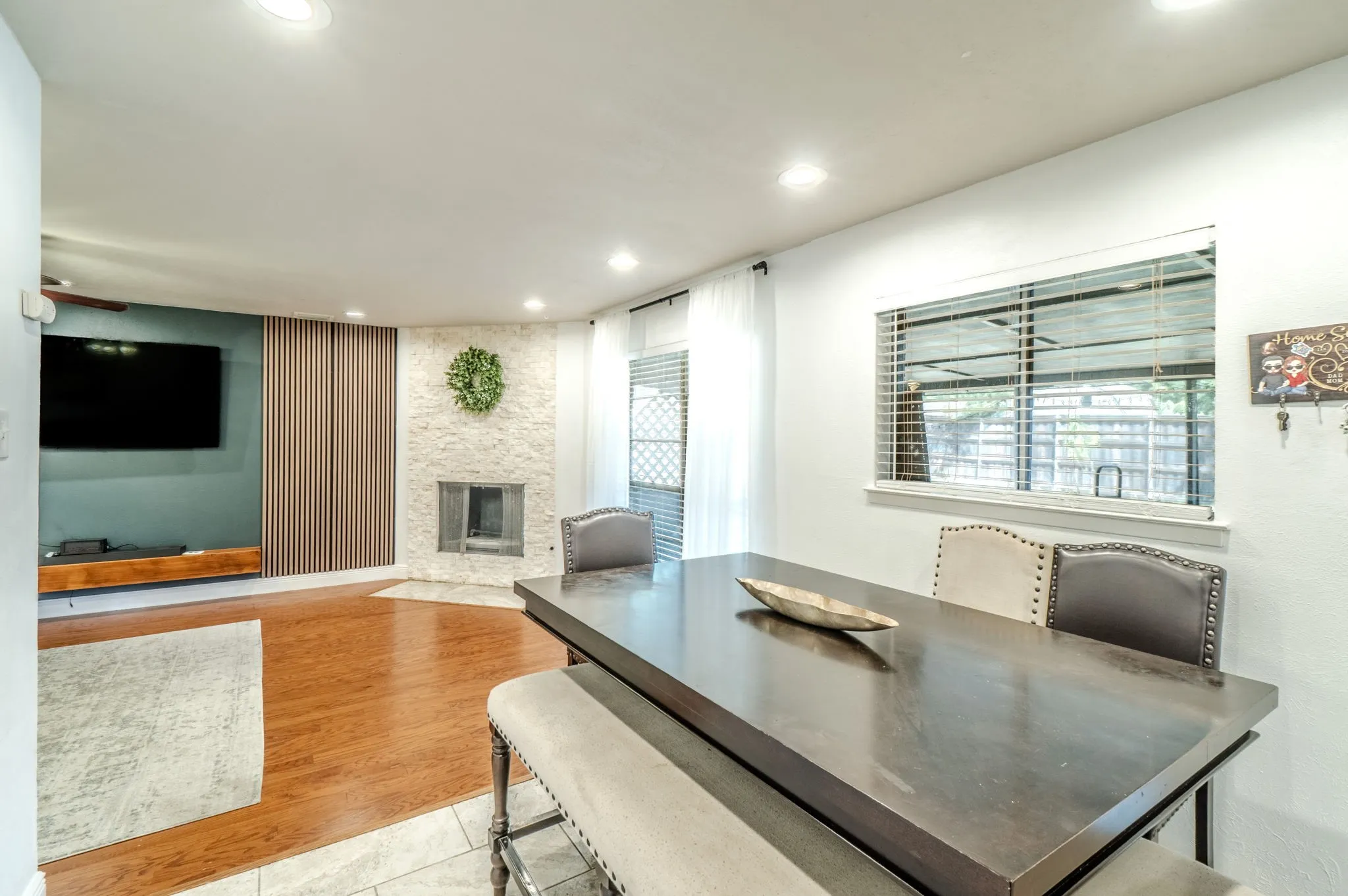 Recessed lighting, wood-finish flooring, stone fireplace surround, ceiling fan, and built-in shelving