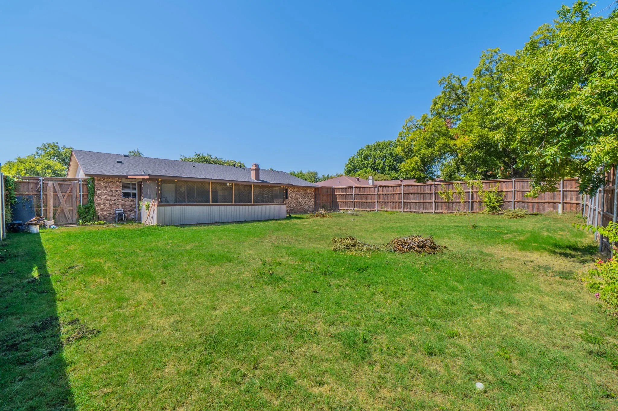 Expansive green lawn with a full wooden privacy fence