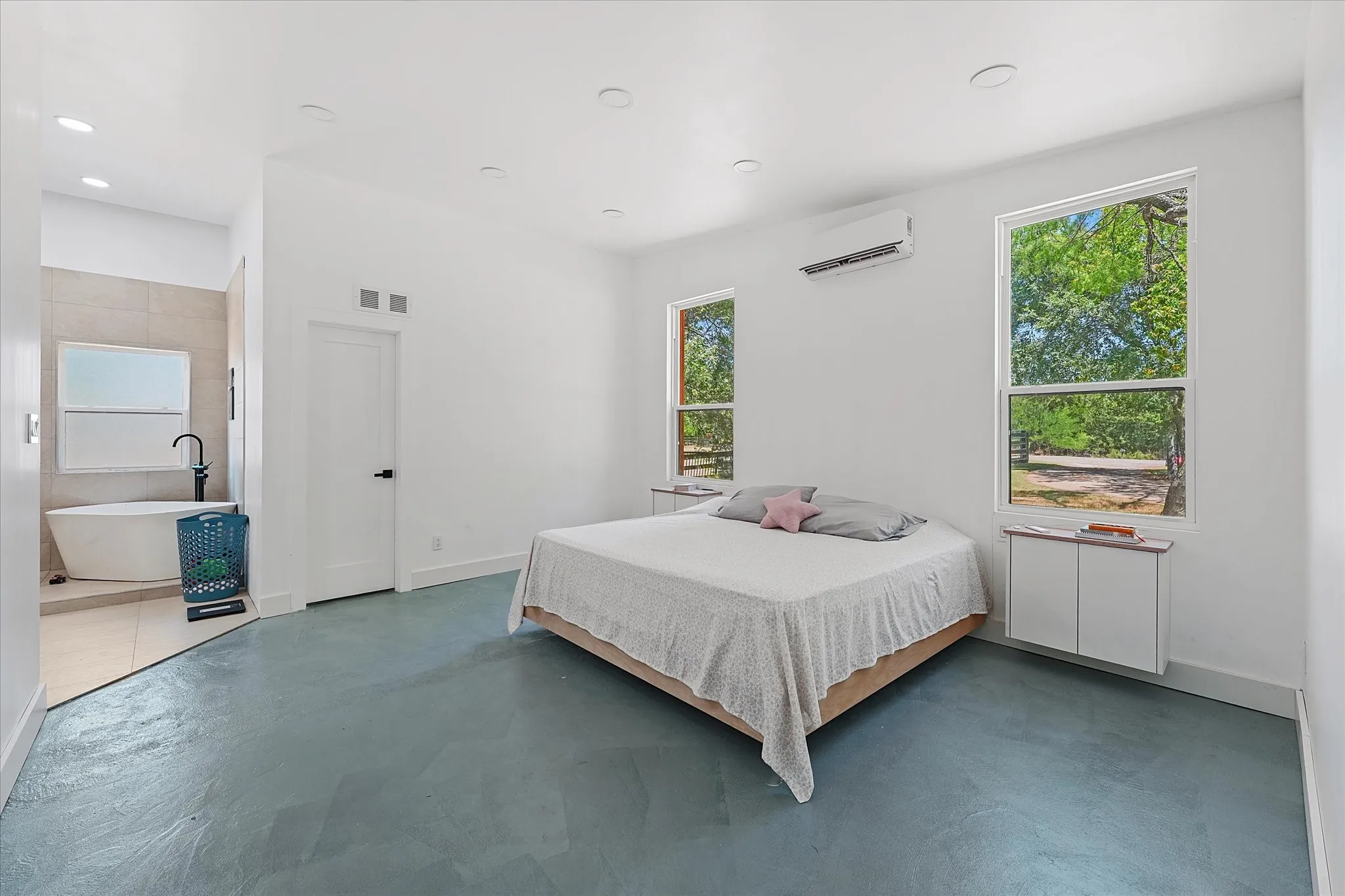 Recessed lighting, light-toned walls, and large windows with exterior views