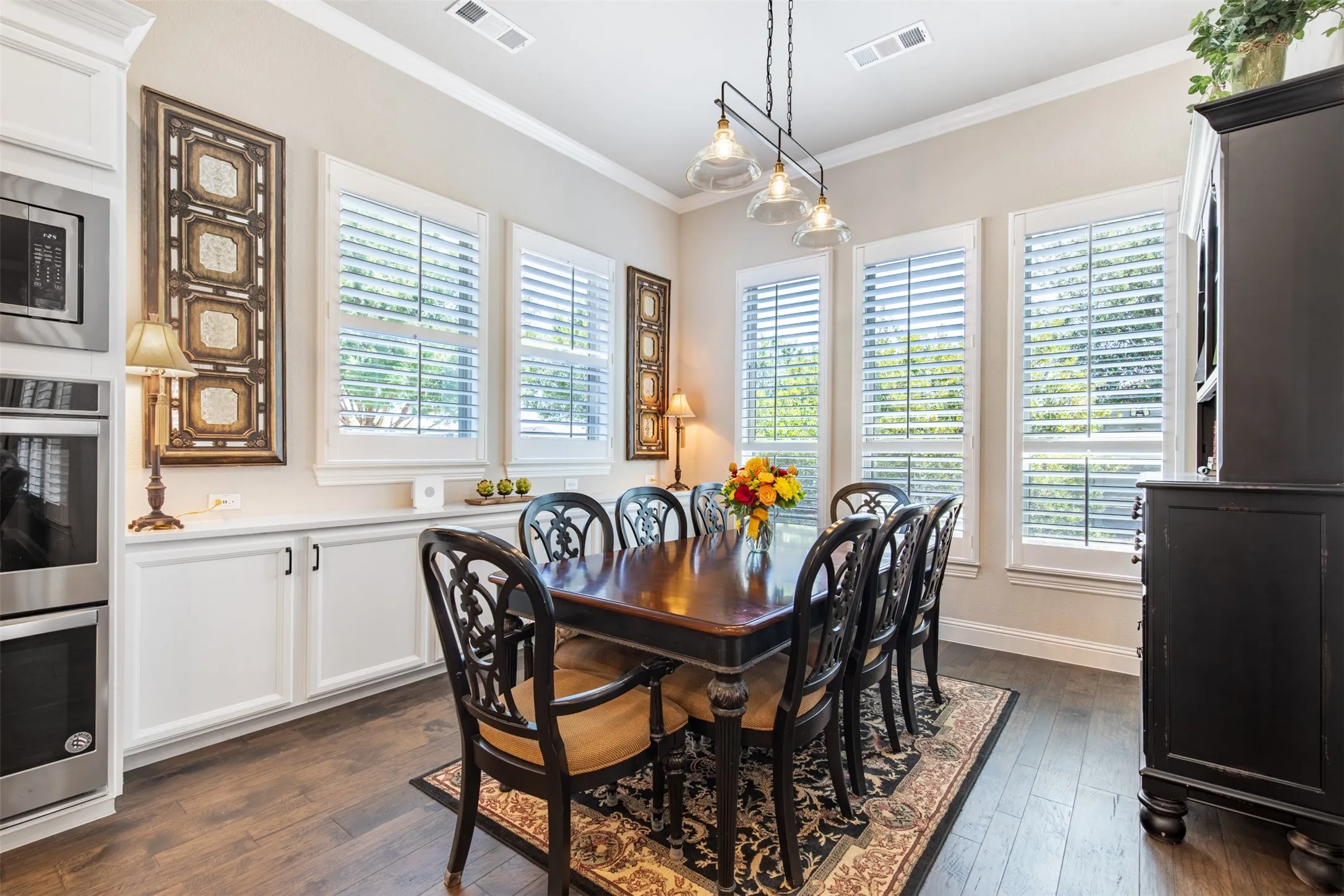 Dining area with built ins located next to the kitchen with a view of the backyard.