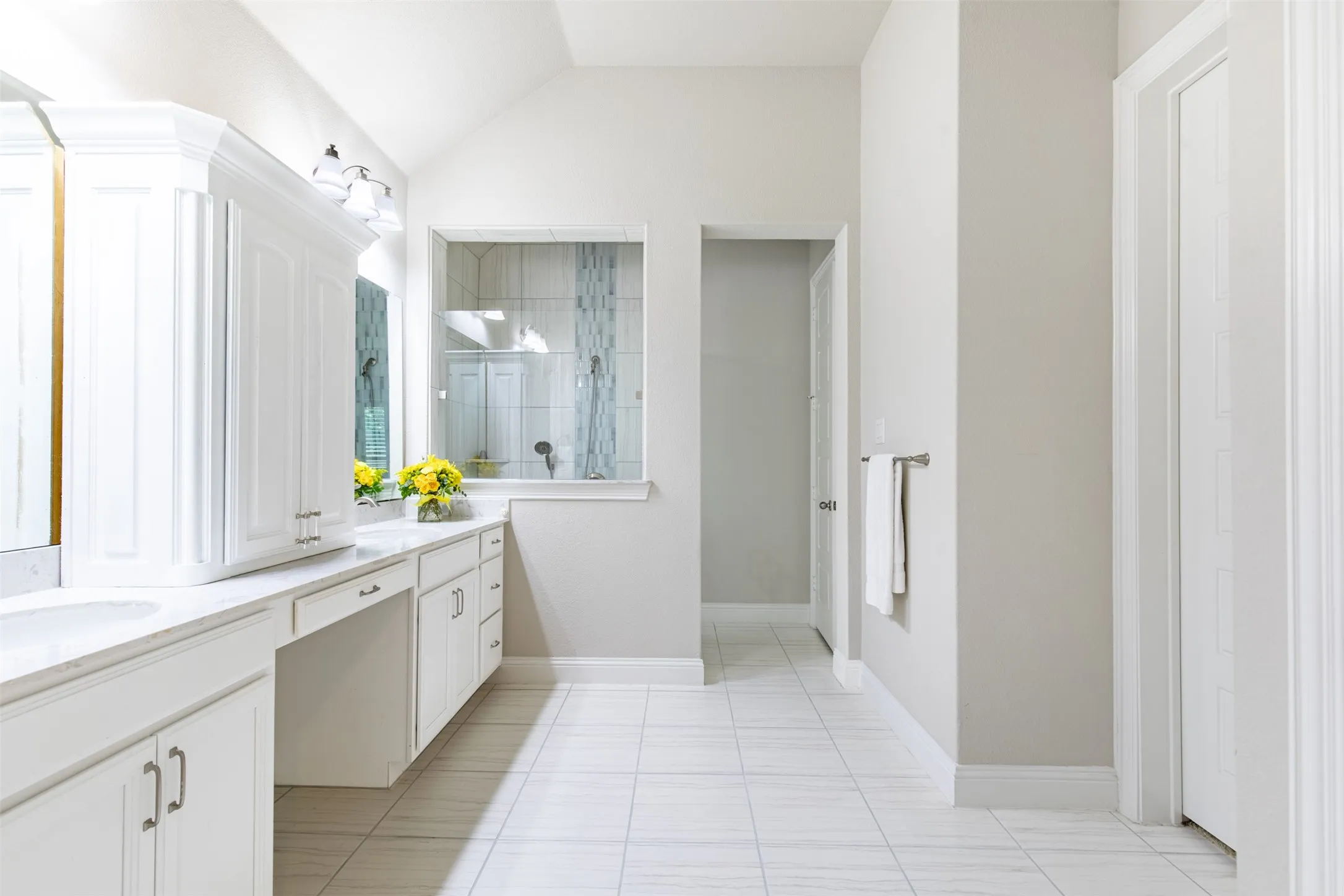 Spacious primary bath with a walk-in shower, plenty of cabinet space, a linen closet and walk-in closet.