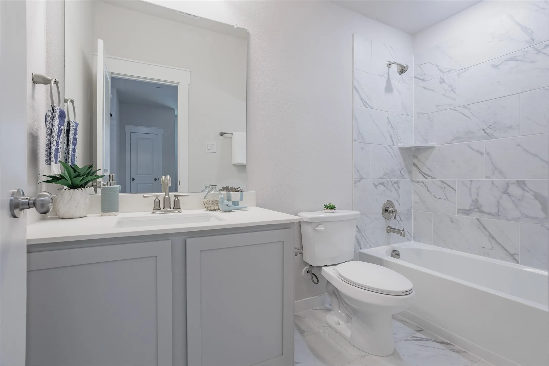 Bathroom is down stairs and right off the bedroom, featuring a single vanity with light gray cabinetry, a white countertop, and a white rectangular sink