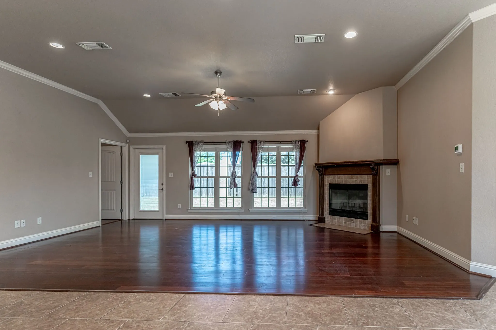 Living room area with new flooring, wood burning fireplace and entrance to backyard