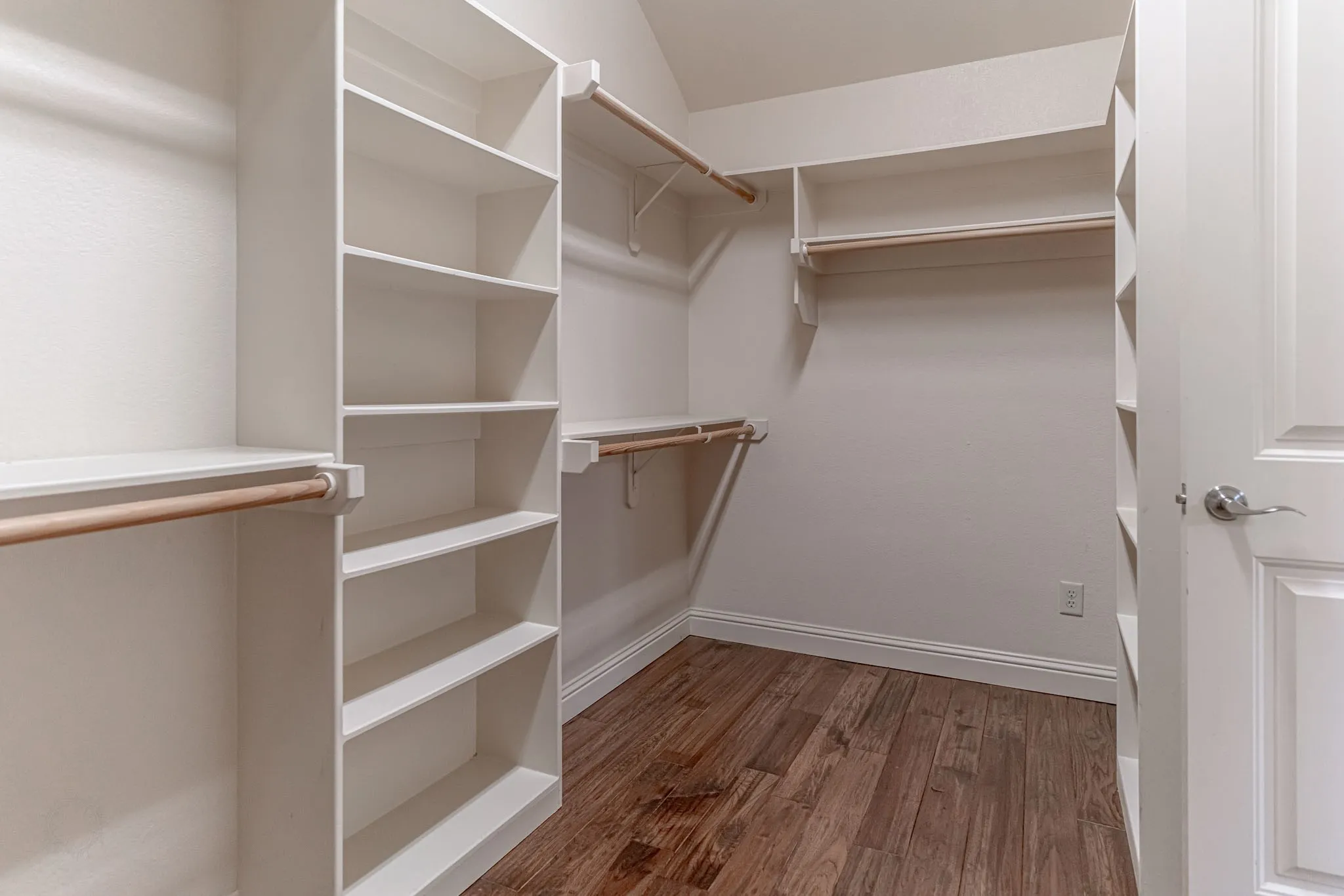 Primary walk in closet with lots of shelf and hanging space