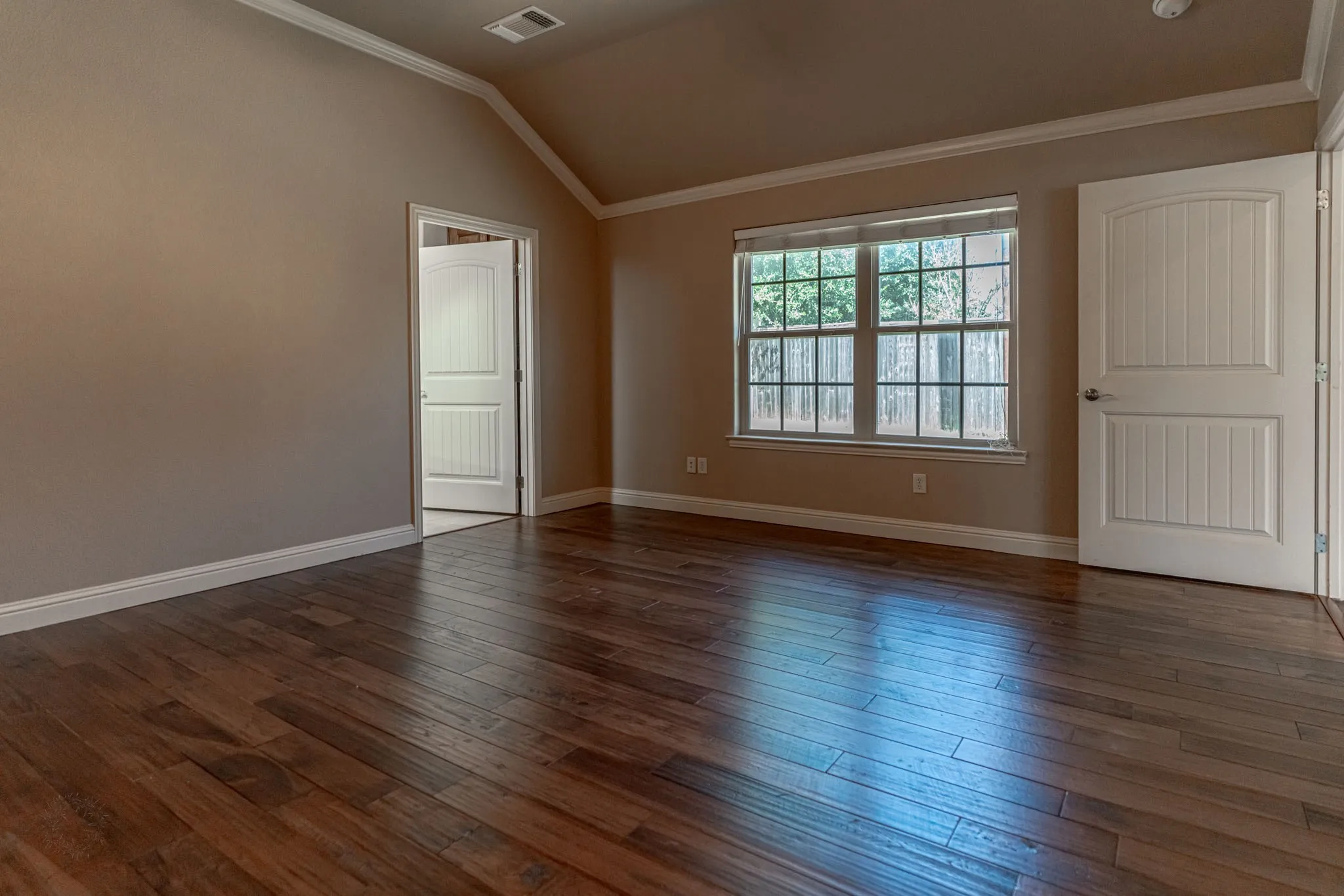 Primary bedroom with windows to the backyard