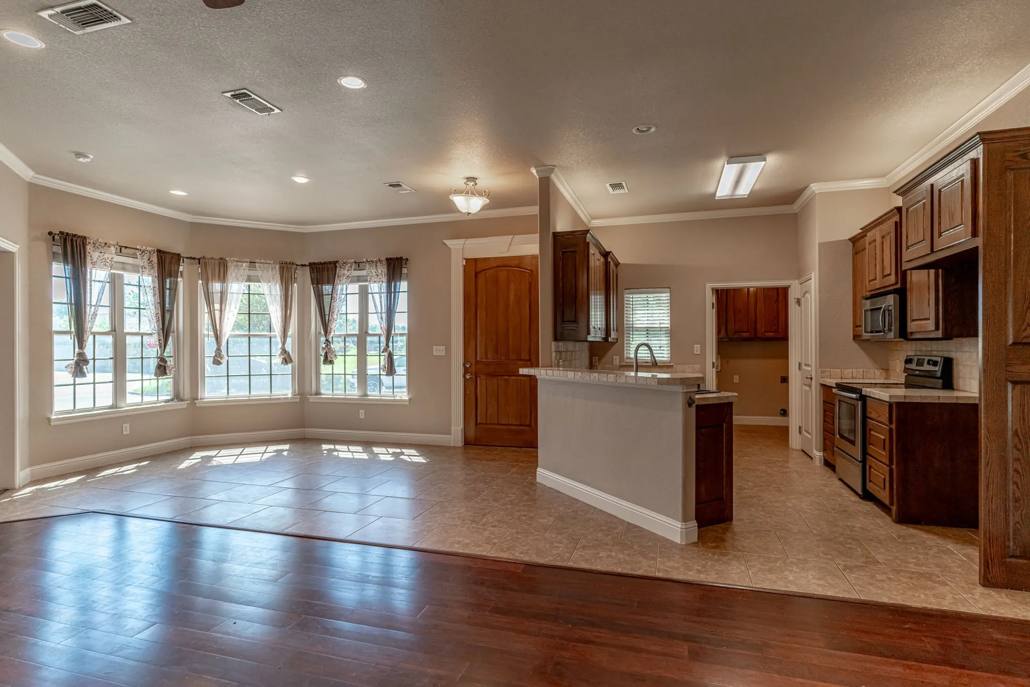 View of dining room and kitchen with breakfast bar and built in appliances.