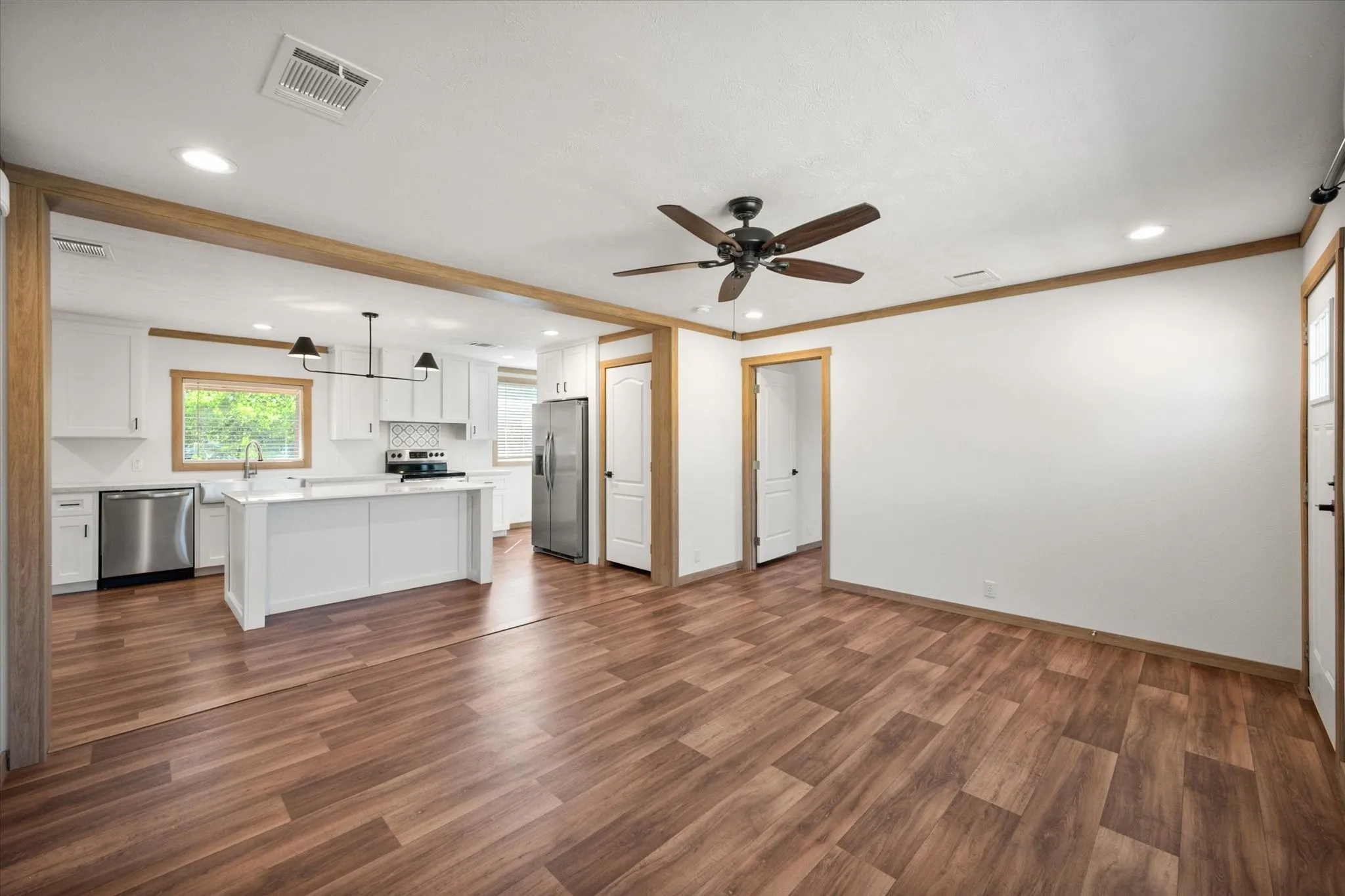 Open living and kitchen layout creates a spacious gathering area with wood-look laminate flooring and contemporary finishes throughout.