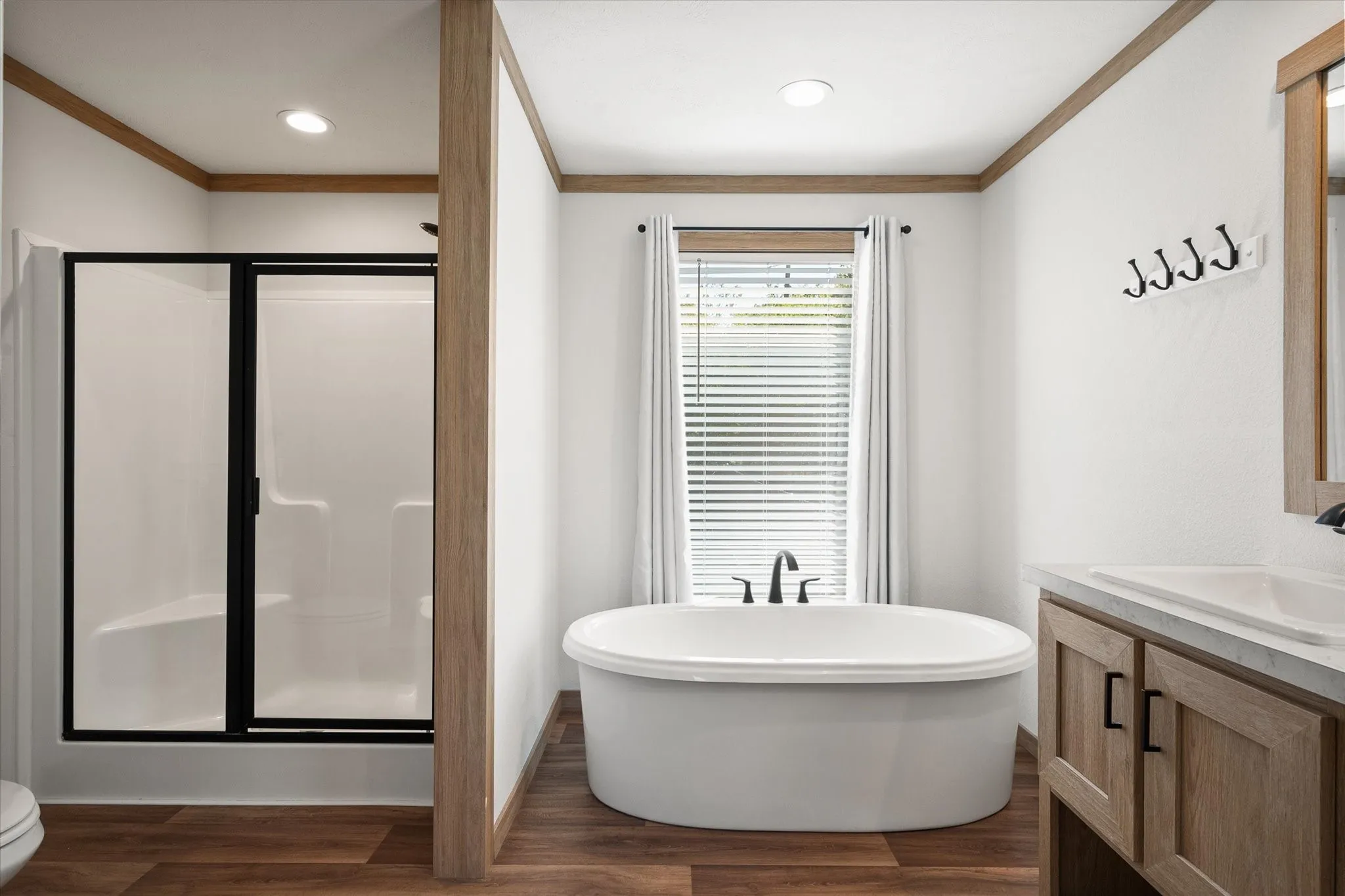 Primary ensuite offers a freestanding garden tub, separate shower and spacious vanity area in this three-bedroom Kerens TX home.