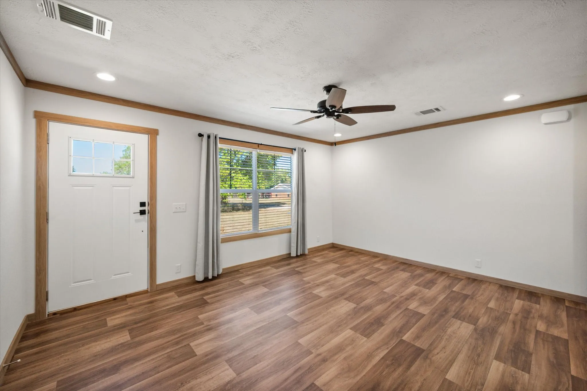 Step out of the primary bedroom and back into the living room to continue through the rest of the home.