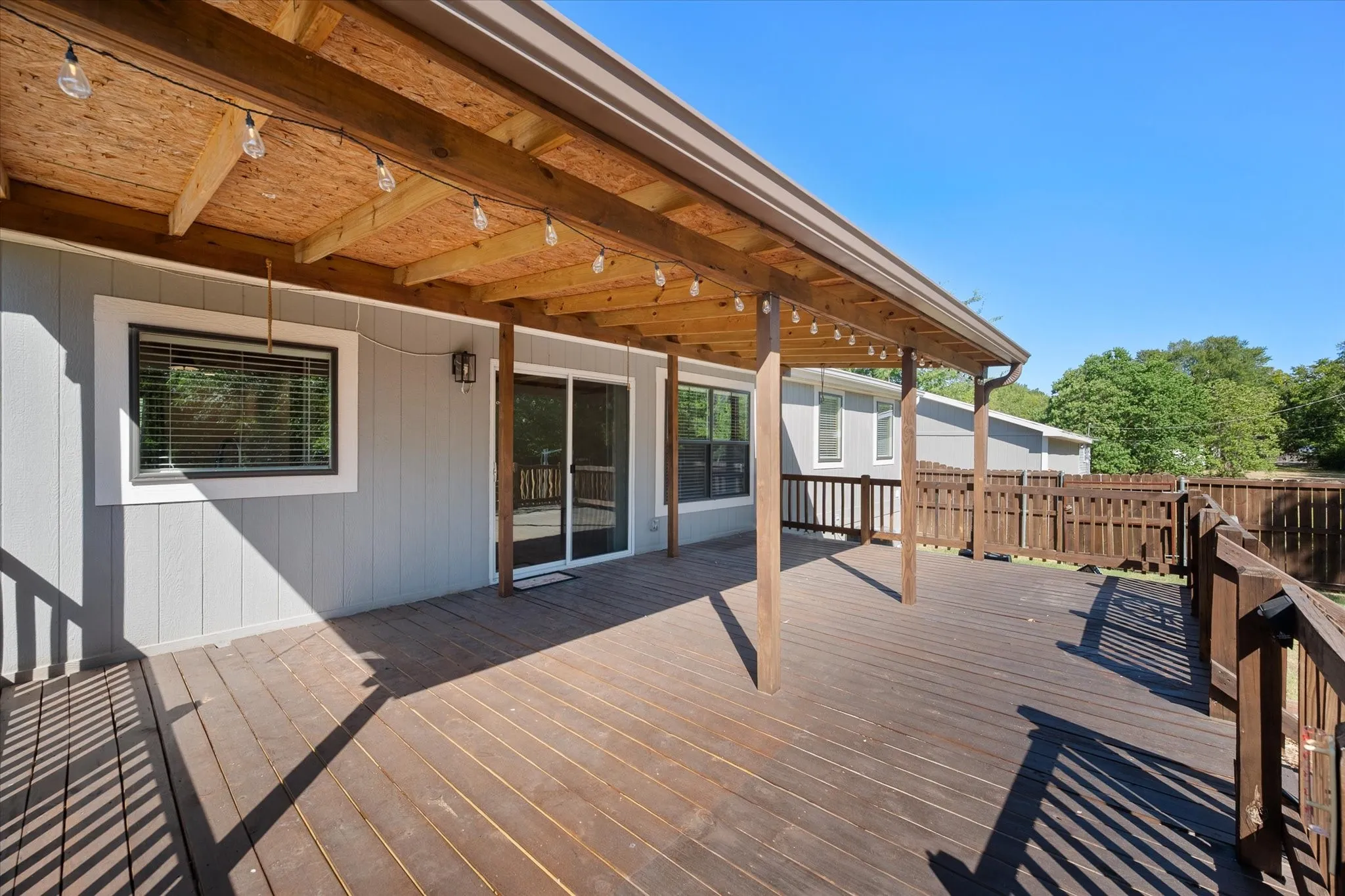 Large covered rear deck offers an inviting outdoor living area overlooking the private fenced backyard at 716 N Wright Avenue.