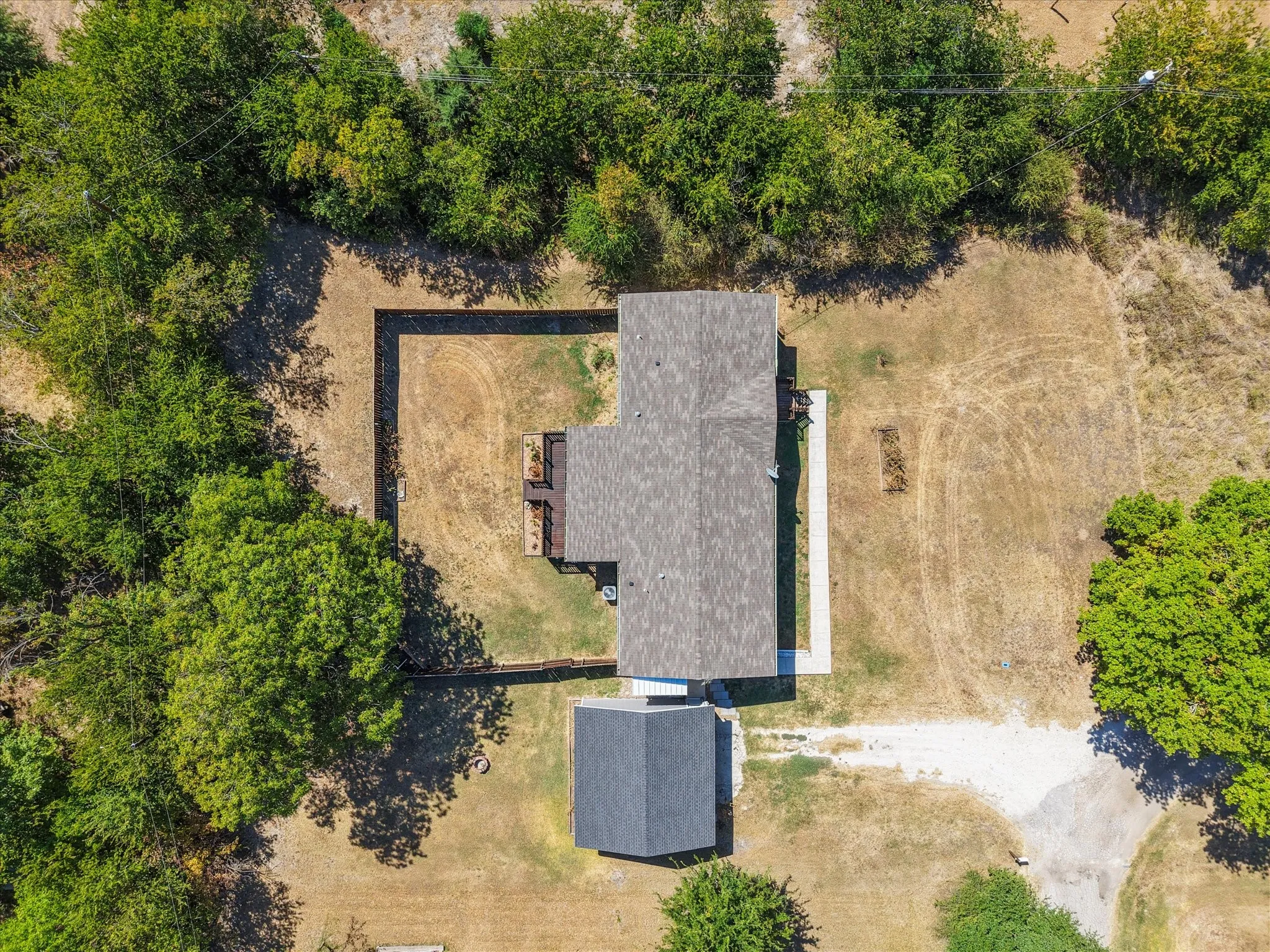 Overhead property view showcases the home's footprint, detached garage, fenced backyard and spacious 0.568-acre lot.