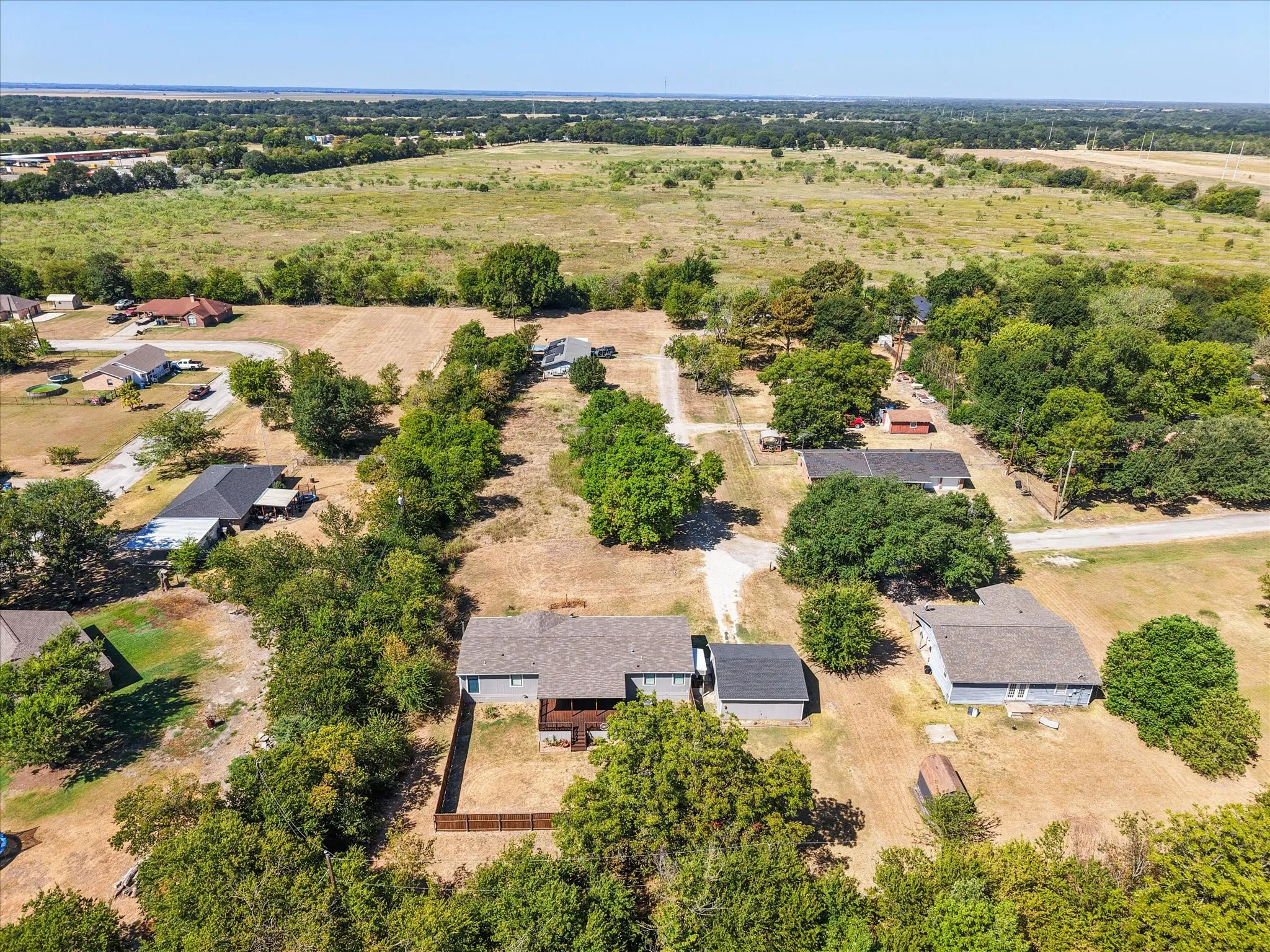 High aerial perspective highlights the property's generous lot and convenient location near both established neighborhoods and open countryside.